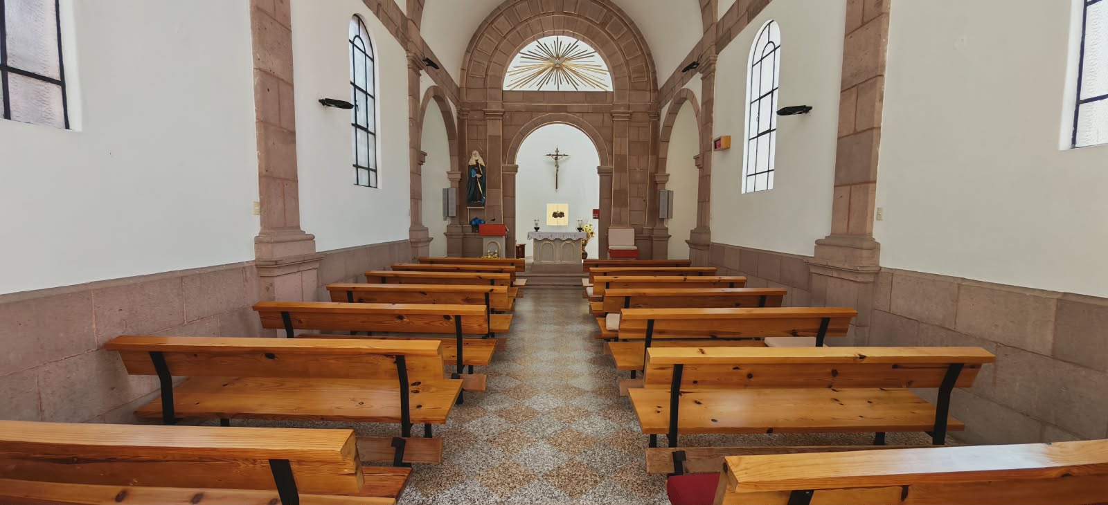 Interior de la iglesia con bancas de madera